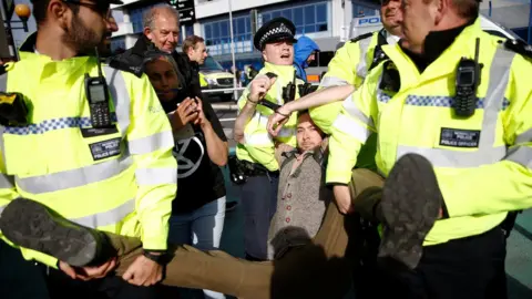 Henry Nicholls/Reuters A protester is carried away by police during a demonstration at London City Airport