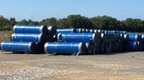 Dozens of blue pipes stacked up on land near Greetwell in Lincoln