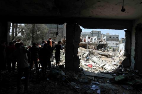 People leave a school hit by an Israeli strike in Gaza