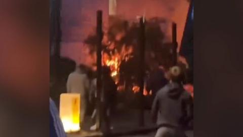 People watch on as a fire takes hold at a hotel in Tamworth