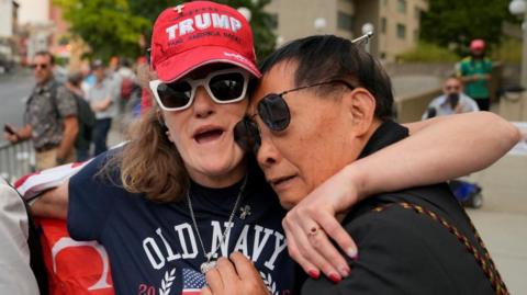 A man and woman embrace outside court after Trump's verdict was announced