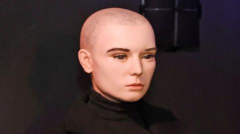 A waxwork figure of singer Sinéad O'Connor wearing a black jumper and black coat