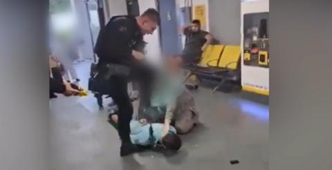 A still from the video shows a police officer poised to stamp on the head of a suspect who is in a prone position with his hands cuffed behind his back