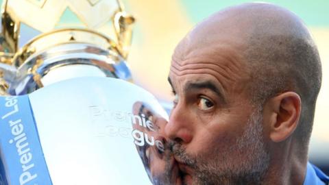 Manchester City manager Pep Guardiola kisses the Premier League trophy
