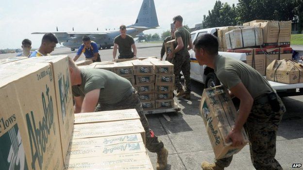 Philippine and US military personnel load relief goods for Tacloban on board a US C-130 plane for victims of Super Typhoon Haiyan that hit the central Philippines, at a military base in Manila on 11 November 2013