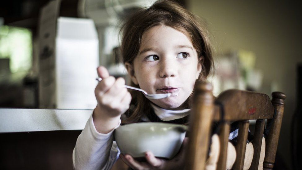 Stock image of a child eating yoghurt