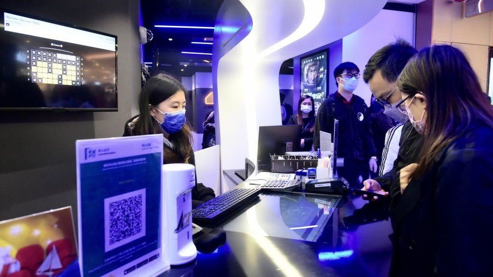 Moviegoers buy tickets at a cinema during its reopening on February 18, 2021 in Hong Kong