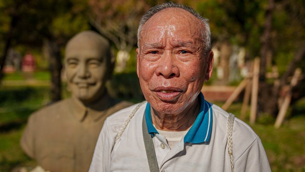 Fan Hsun-chung standing next to a statue of Chiang Kai-shek