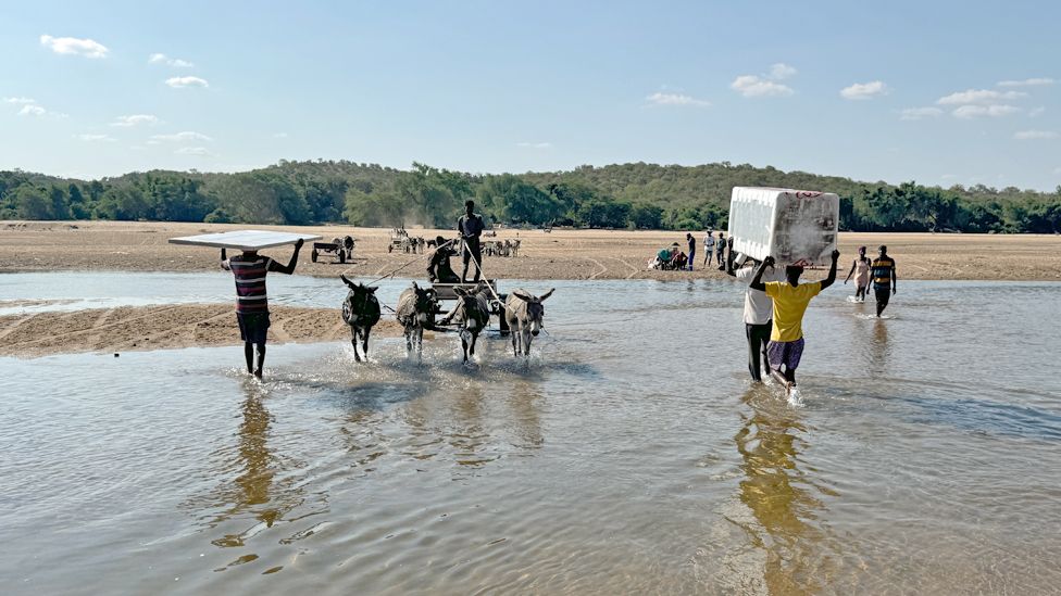 People crossing the Limpopo River from Zimbabwe into South Africa