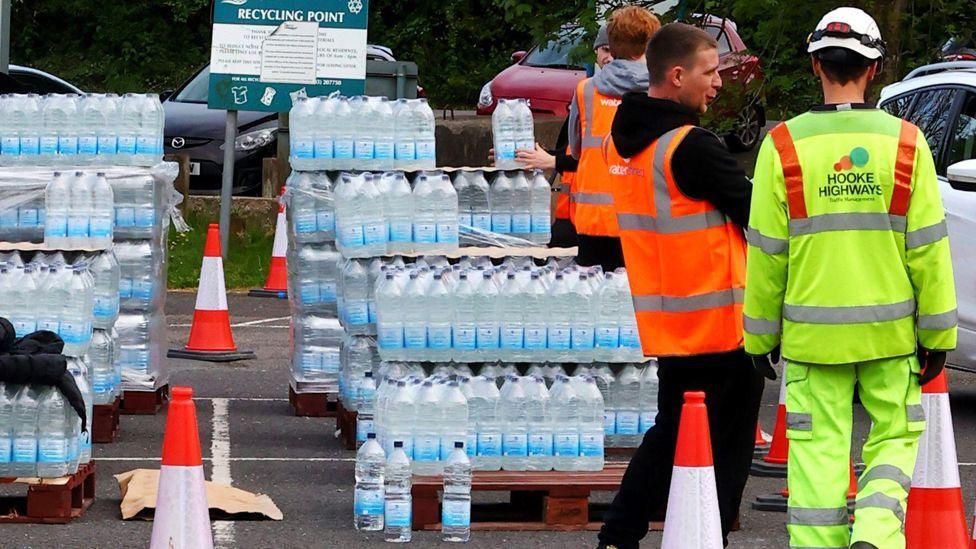 Workers handing out bottled water