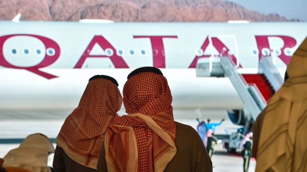 Journalists watch the arrival of Qatar's envoy ahead of the 41st Gulf Cooperation Council (GCC) summit in the Saudi city of al-Ula (5 January 2021)