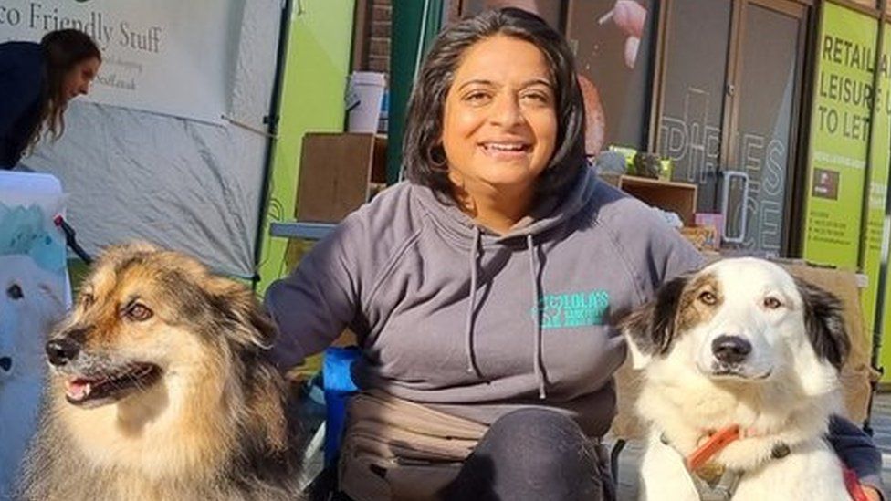 Poonam Doshi with two dogs by a charity stall