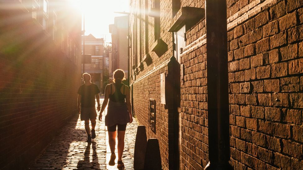 The sun sets over an alleyway in a residential area of the Stoke Newington district of London