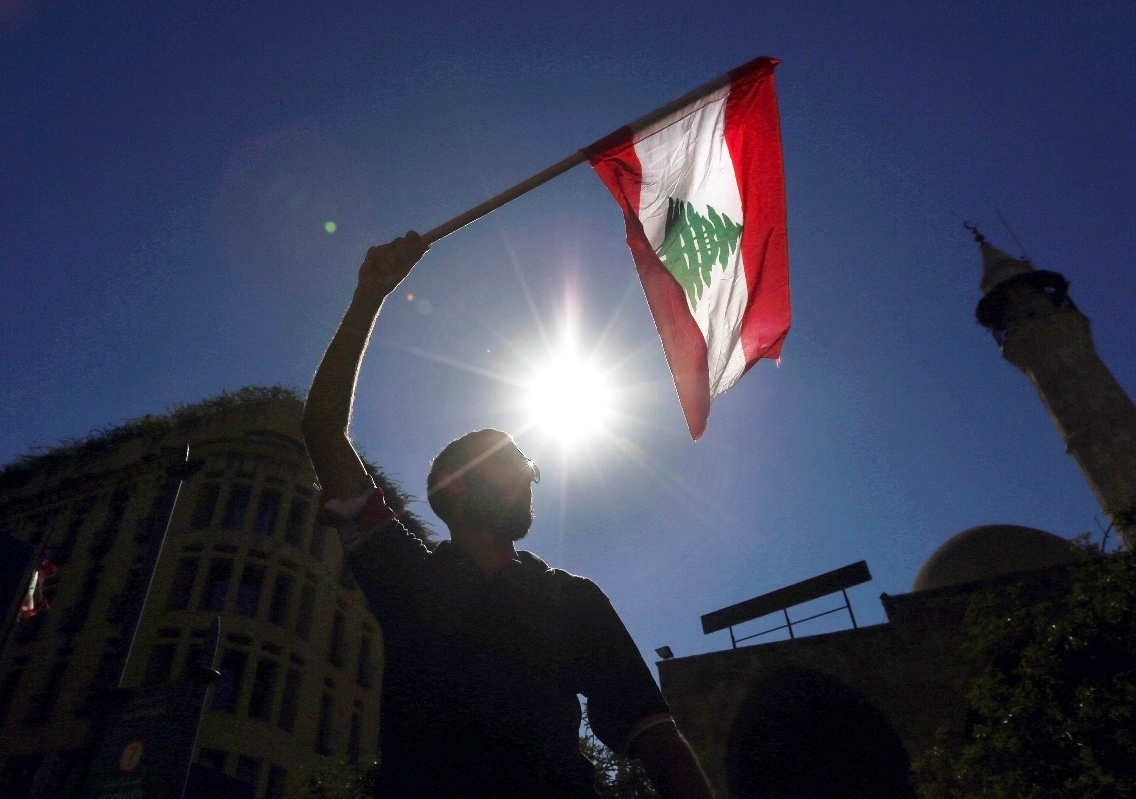 A man waves a Lebanese flag during a protest near the parliament building in downtown Beirut, Lebanon, AP Photo/Bilal Hussein