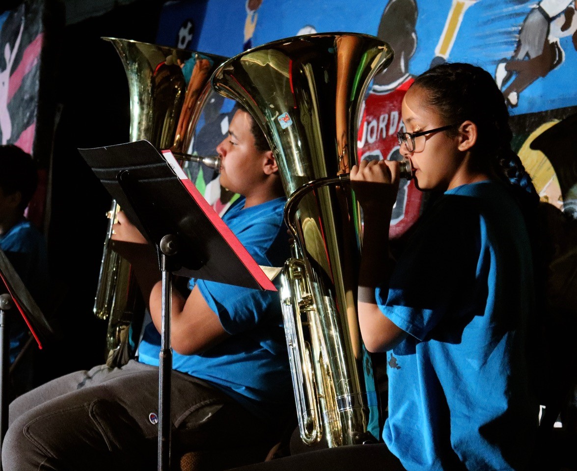 Euphonium players on stage in blue shirts