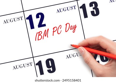 August 12. Hand writing text IBM PC Day on calendar date. Save the date. Holiday.  Important date. Day of the year concept.