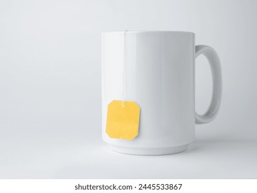 White ceramic mug with teabag label isolated on a white background