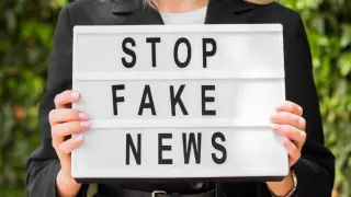 Mujer con un cartel de 'Stop fake news'