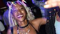 Nuori kevyesti pukeutunut nainen tanssii ugandalaisella musiikkifestivaalilla yövalaistuksessa. 