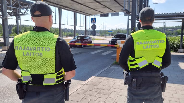 Photo shows two border guards watching traffic on Finland's eastern border with Russia, June 2023.