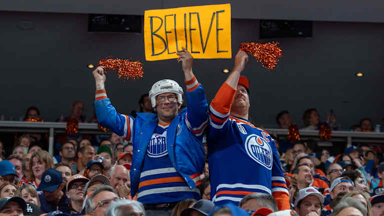 Kaksi Edmontonin fania pitää katsomossa kylttiä, jossa lukee Believe.