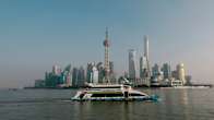 En vy från havet mot Shanghais finansdistrikt. En färja i förgrunden.