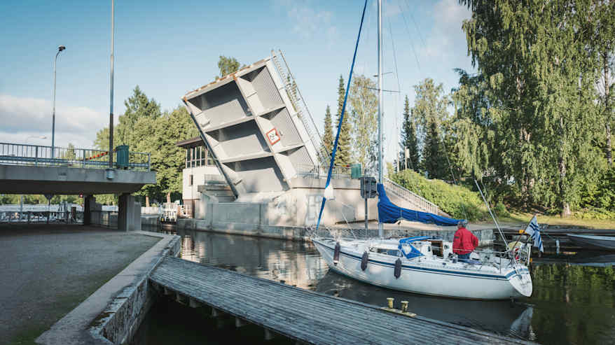 En klaffbro har lyfts upp och en segelbåt väntar på att få åka in i en kanal.