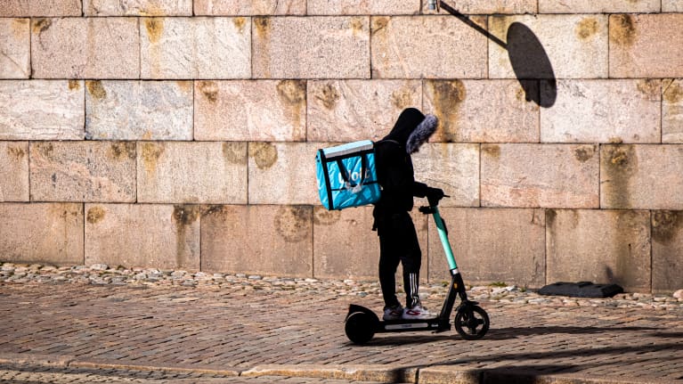 Woltin ruokalähetti viemässä ruokaa asikkaalle.