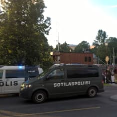 en polisbild och en militärpolisbil utanför aussie bar i åbo