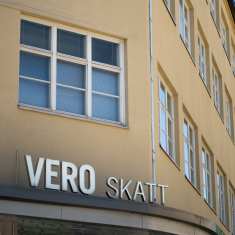 Skatteförvaltningens huvudkontor, en beige byggnad med en skylt med texten "skatt" på.