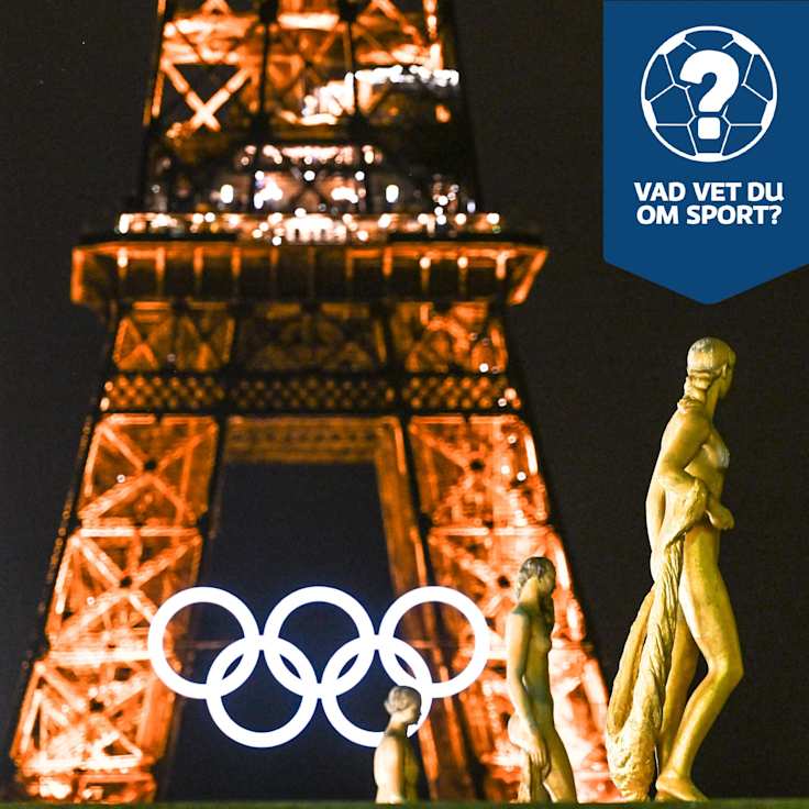 OS-ringarna lyser framför Eiffeltornet.