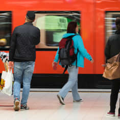 Ihmisiä astumassa metrojunaan, metro Helsingin Rautatieasema