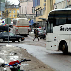 Bilar, fotgängare och bussar vid en korsning.