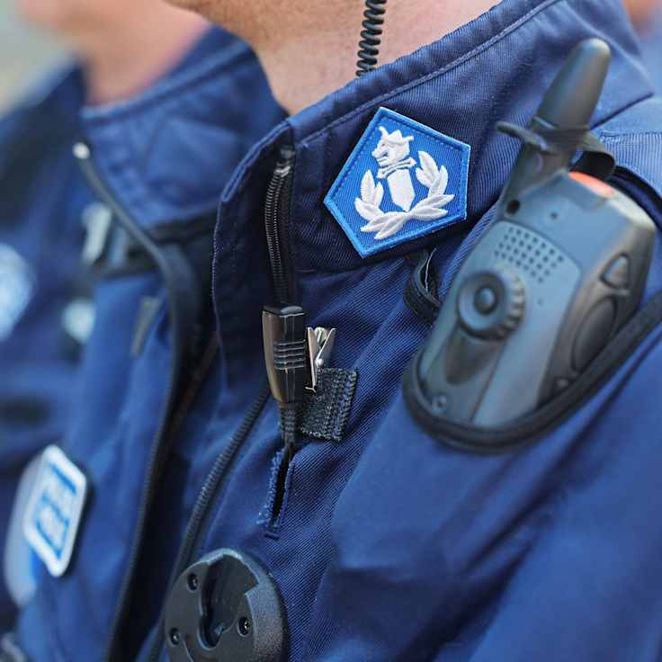 En anonym polis. Endast överkroppen iklädd uniform syns.