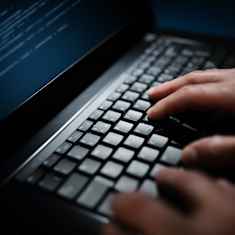 Photo showing hands on a computer keyboard.