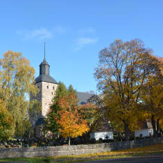 Korpo kyrka inbäddad i vackra höstfärger.