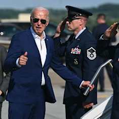 USA:s president Joe Biden ger tummen upp medan soldater gör honnör vid Air Force One:s trappa.