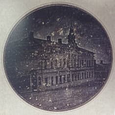 Frimärke och postkort av Finlands första fotografi, vilket Henrik Cajander 1842 tog av det Nobelska huset i Åbo.