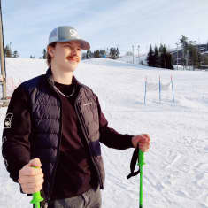 Miikka Nieminen håller i ett par stavar där han står i en snöig Påminnebacke i Pojo.