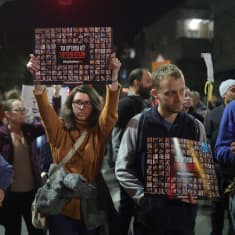 Israeliska demonstranter visar upp bilder på personer som Hamas tagit som gisslan.