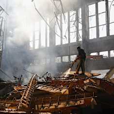 Ukrainian rescuers work at the site of a rocket strike.