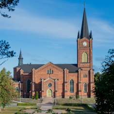 En kyrka i rödtegel fotad på avstånd.