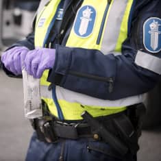 En polis håller ett drogtest i handen.