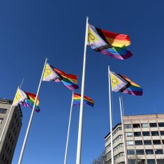 Prideflaggor mot en blå himmel.