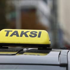 En taxiskylt ovanpå ett biltak.