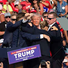 Secret Service agents surround Donald Trump. 