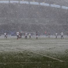 Det snöar under en fotbollsmatch.