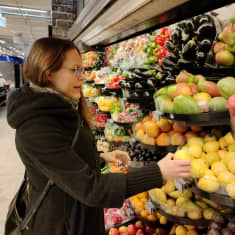 Näringsvetare Charlotta Hyttinen vid frukthyllan i en matbutik.