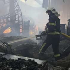 En brandman släcker en brand i en förstörd byggnad.