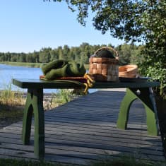 En grön ljugarbänk på bryggan vid Strömsöstranden.